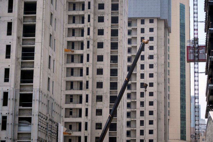 A crane is seen amid residential buildings under construction in Shanghai, China, on 20 July 2022. (Aly Song/Reuters)