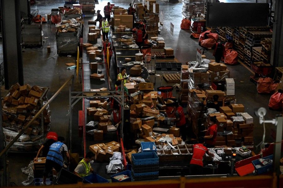 Workers sort packages for delivery at a JD.com warehouse in Beijing on 8 September 2022. (Jade Gao/AFP)