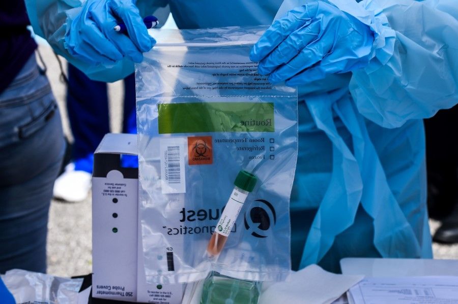 A medical personnel stores medical samples of patients at a "drive-thru" coronavirus testing lab in West Palm Beach, Miami, March 16, 2020. (Chandan Khanna/AFP)