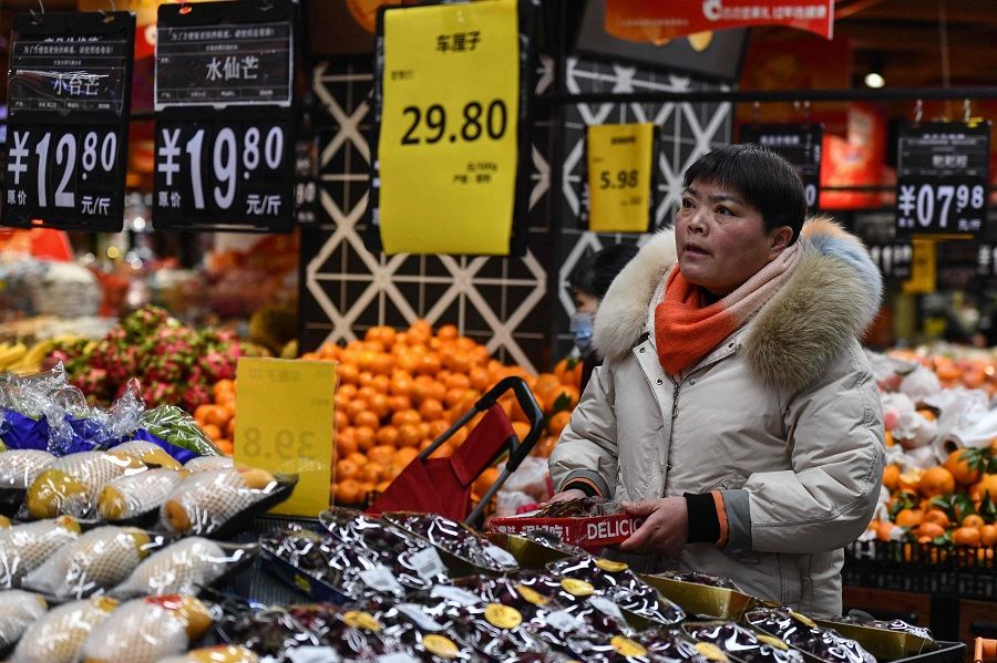 A customer shops for vegetables and fruit at a supermarket in Fuyang, in eastern China’s Anhui province on 8 February 2024. (AFP)