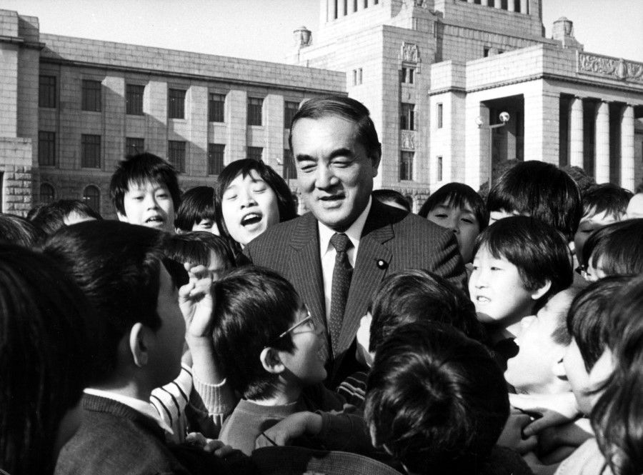 Yasuhiro Nakasone surrounded by a group of elementary school students outside the Diet building, 1988. (SPH)