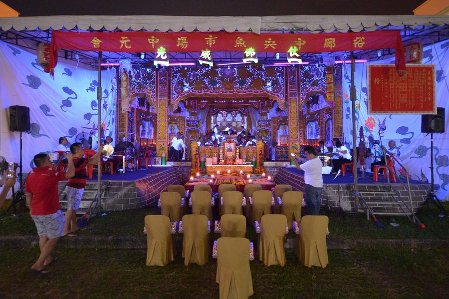 Prayers and rituals are conducted on stage, behind a feast that has been laid for the spirits during the Hungry Ghost Festival at Jurong Fishery Port on 18 August 2016. Food offerings are seen as a way of appeasing wandering spirits, while prayers help relieve them of suffering. Seats near the stage have been left empty for the spirits. (SPH)