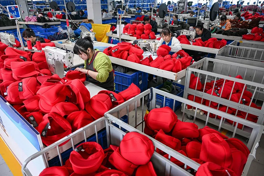 Employees work on a production line of caps that will be exported to the United States at a factory in Suqian, Jiangsu province, China, on 7 April 2025.