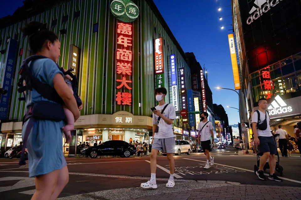 Pedestrians crossing a street in Taipei, Taiwan, on 25 July 2023. (Ann Wang/Reuters)