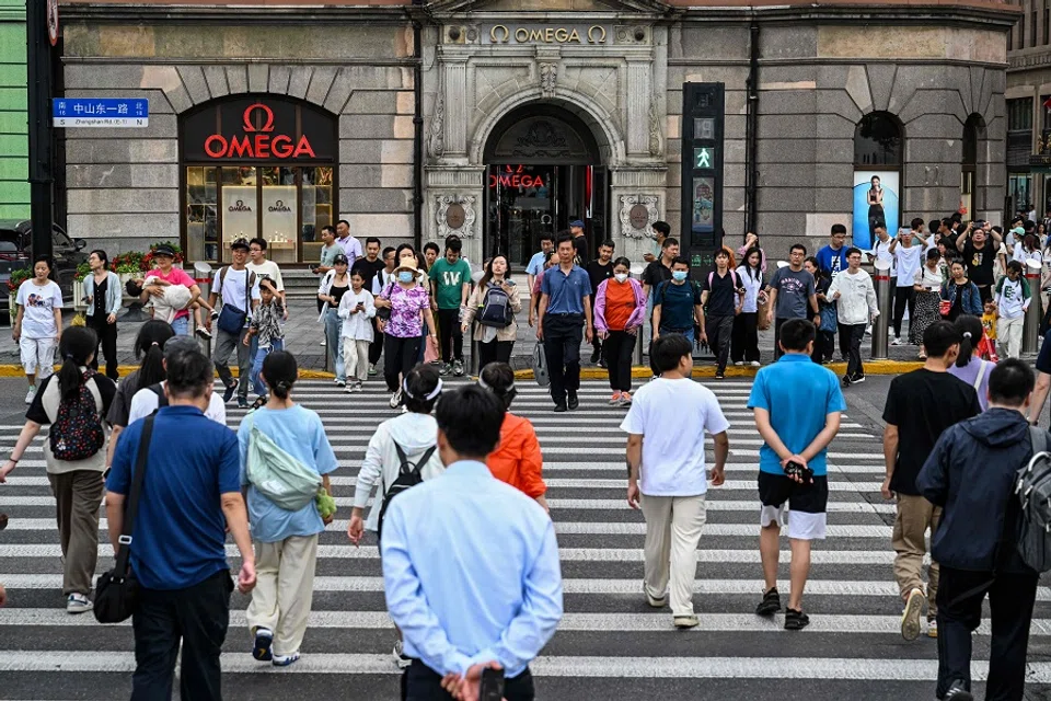 People cross a street on the Bund in the Huangpu district in Shanghai, China, on 15 June 2023. (Hector Retamal/AFP)