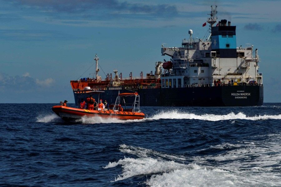 A dinghy (left) from Indonesia's National Search And Rescue Agency (BASARNAS) returns to their vessel after evacuating a Russian crew member from the Danish tanker Hulda Maersk (right) for medical reasons, at sea off the coast of Aceh on 27 April 2021. (Chaideer Mahyuddin/AFP)