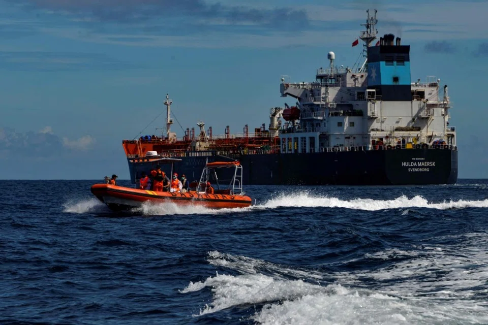 A dinghy (left) from Indonesia's National Search And Rescue Agency (BASARNAS) returns to their vessel after evacuating a Russian crew member from the Danish tanker Hulda Maersk (right) for medical reasons, at sea off the coast of Aceh on 27 April 2021. (Chaideer Mahyuddin/AFP)