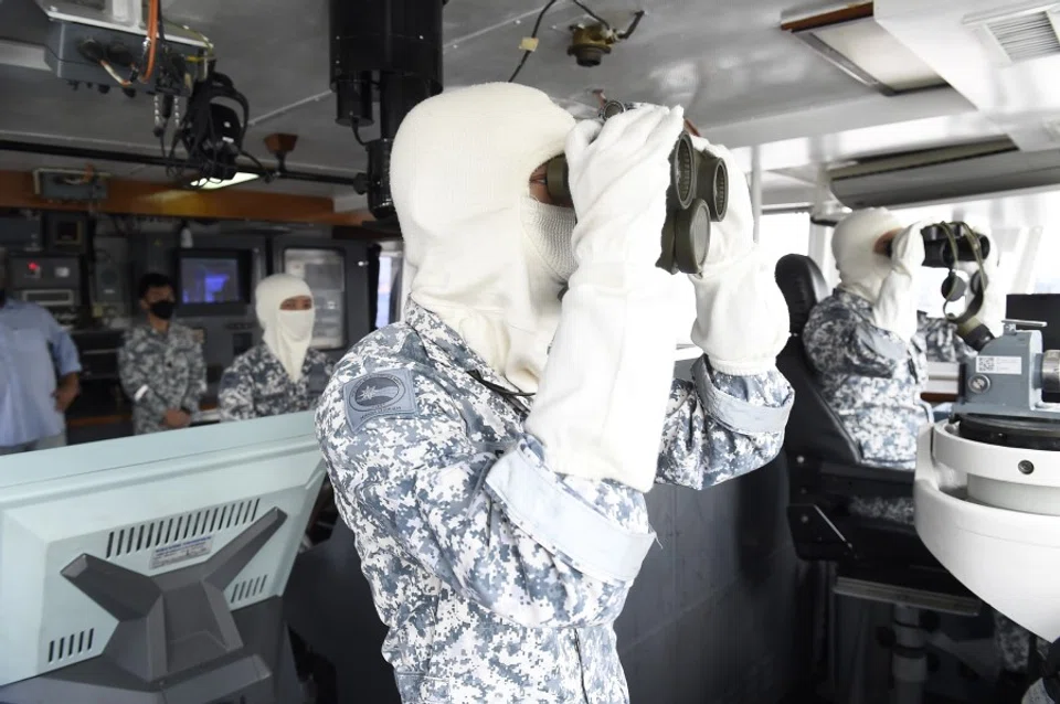 A crew member on the RSS Vigour acting as the lookout at the bridge as the team investigates a potential contact of interest. (MINDEF)