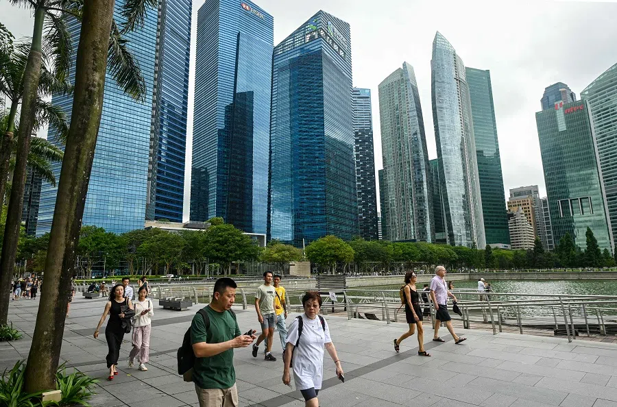 People walk along the promenade at Marina Bay in Singapore on 27 January 2025. (Roslan Rahman/AFP)