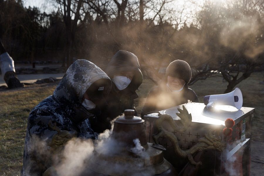 Vendors prepare hot drinks in Yuanmingyuan Park on a cold day in Beijing, China, 23 January 2023. (Thomas Peter/Reuters)