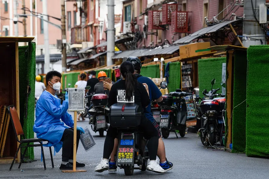 A community volunteer gestures to residents at an entrance in a residential area under a Covid-19 lockdown in Shanghai's Huangpu district on 22 June 2022. (Liu Jin/AFP)