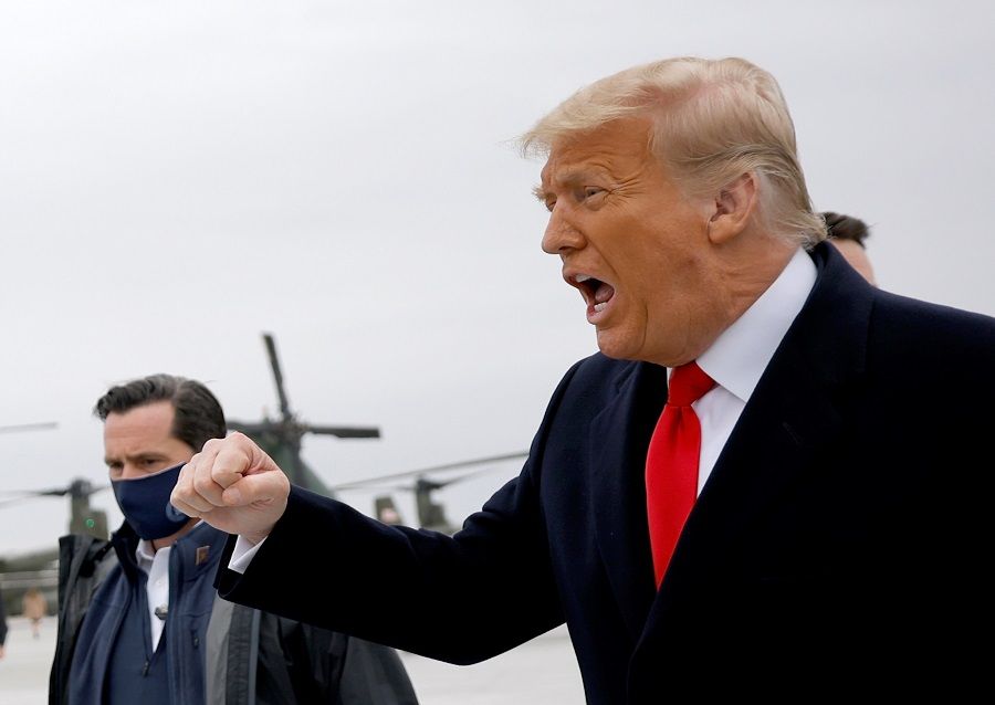 US President Donald Trump gestures as he disembarks from Air Force One at Valley International Airport before departing to Alamo to visit the US-Mexico border wall, in Harlingen, Texas, US, 12 January 2021. (Carlos Barria/Reuters)