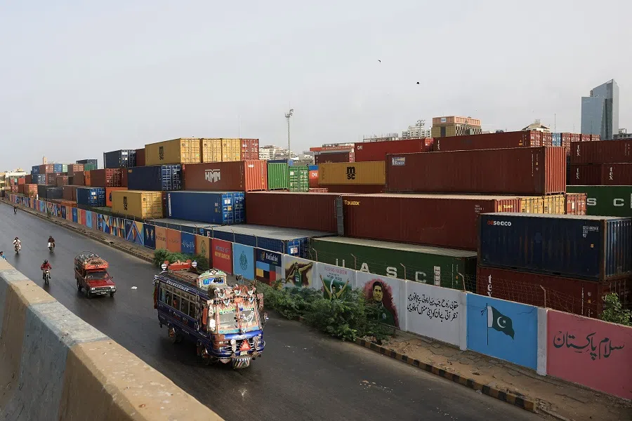Vehicles move past a shipping container yard along a road in Karachi, Pakistan, on 10 June 2025. (Akhtar Soomro/Reuters)