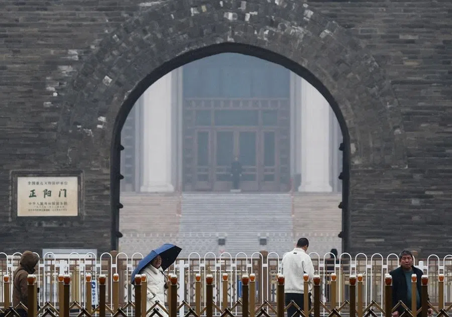 People walk past fences near Zhengyangmen Gate Tower in Beijing, China, on 2 March 2026. (Maxim Shemetov/Reuters)