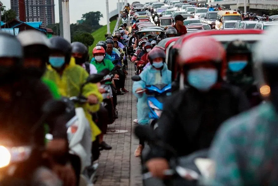 Local people are seen on their vehicles as they get stuck in traffic while the VIP convoys pass during the ASEAN foreign ministers meeting in Phnom Penh, Cambodia, 3 August 2022. (Soe Zeya Tun/Reuters)