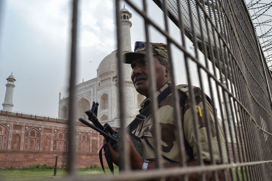A member of security personnel stands guard behind a perimeter fence at the Taj Mahal in Agra, India, on 20 May 2022. (Pawan Sharma/AFP)