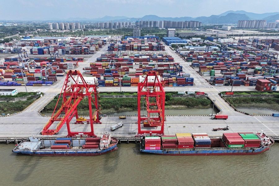 In this photo taken on 6 August 2023, a truck drives between containers at Nanjing port in Nanjing, Jiangsu province, China. (Stringer/AFP)