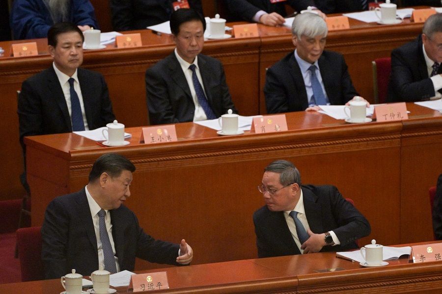Chinese President Xi Jinping (front, left) speaks with Premier Li Qiang during the opening ceremony of the Chinese People's Political Consultative Conference (CPPCC) at the Great Hall of the People in Beijing on 4 March 2024. (Pedro Pardo/AFP)