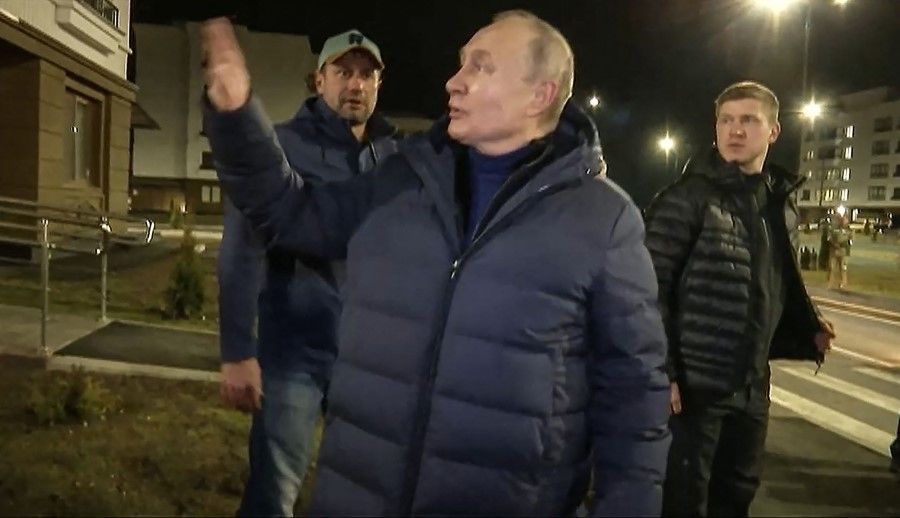 This handout video grab released by Russian Presidential Press Office on 19 March 2023, shows Russian President Vladimir Putin speaking with people in a newly built neighbourhood during his visit to Mariupol in the Russia-controlled Donetsk region. (Handout/Russian Presidential Press Office/AFP)