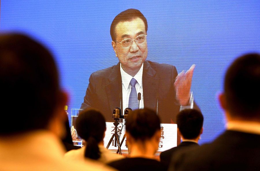 Chinese Premier Li Keqiang is seen on a screen during a press conference held via online video link following the National People's Congress at the Great Hall of the People in Beijing on 28 May 2020. (Noel Celis/AFP)