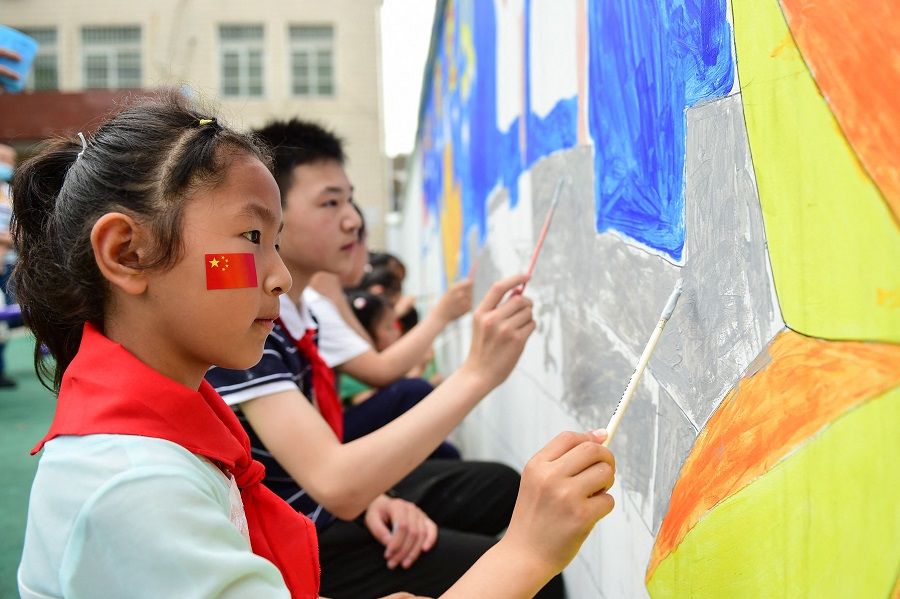 This photo taken on 27 May 2021 shows a student painting on a wall ahead of the Children's Day in Hefei, Anhui province, China. (STR/AFP)