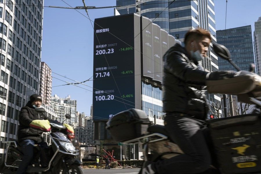Motorists travel past a screen displaying stock figures in Shanghai, China, on 18 February 2021. (Qilai Shen/Bloomberg)