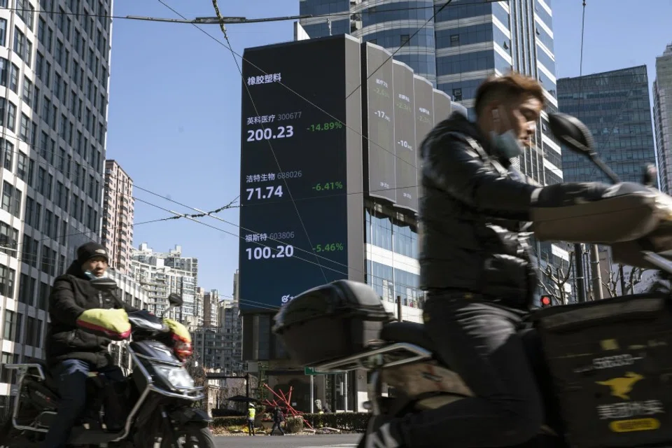 Motorists travel past a screen displaying stock figures in Shanghai, China, on 18 February 2021. (Qilai Shen/Bloomberg)