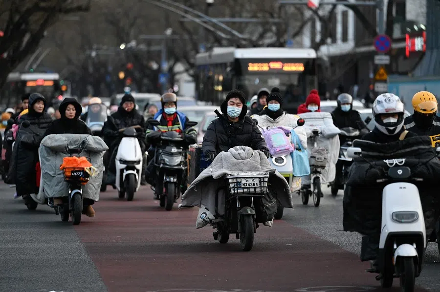 People ride electric bicycles along a street during rush hour in Beijing, China, on 24 February 2025. (Wang Zhao/AFP)