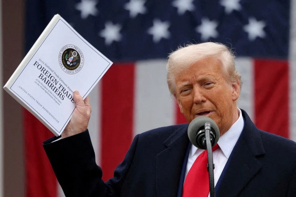 US President Donald Trump holds a “Foreign Trade Barriers” document as he delivers remarks on tariffs in the Rose Garden at the White House in Washington, DC, US, on 2 April 2025. (Carlos Barria/Reuters)