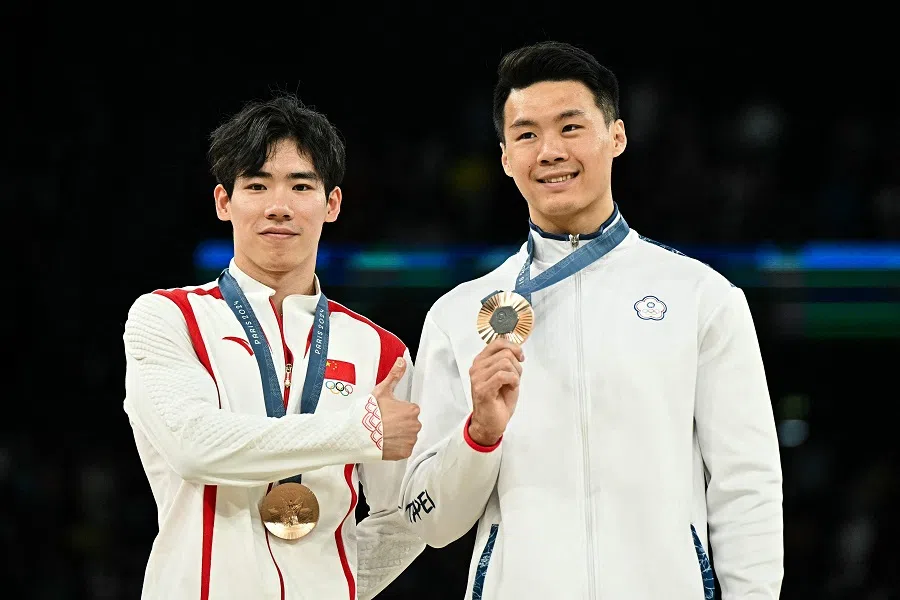 The People’s Republic of China’s Zhang Boheng (left) and Chinese Taipei’s Tang Chia-hung pose with their bronze medal during the podium ceremony for the artistic gymnastics men’s horizontal bar event of the Paris 2024 Olympic Games at the Bercy Arena in Paris, France, on 5 August 2024. (Gabriel Bouys/AFP)