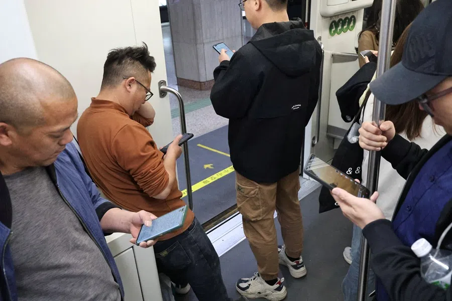 People use their smartphones on a subway car in Shanghai, China, on 14 April 2025.  (Go Nakamura/Reuters)