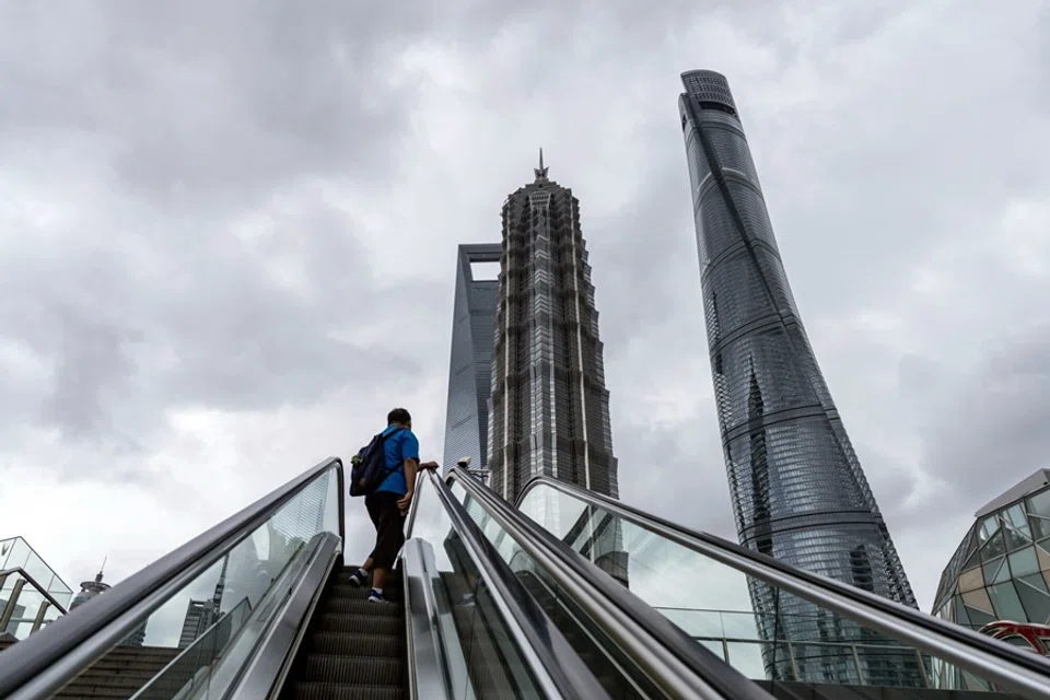 A pedestrian on an escalator in front of buildings in Pudong’s Lujiazui financial district in Shanghai, China, on 10 September 2025. (Qilai Shen/Bloomberg)