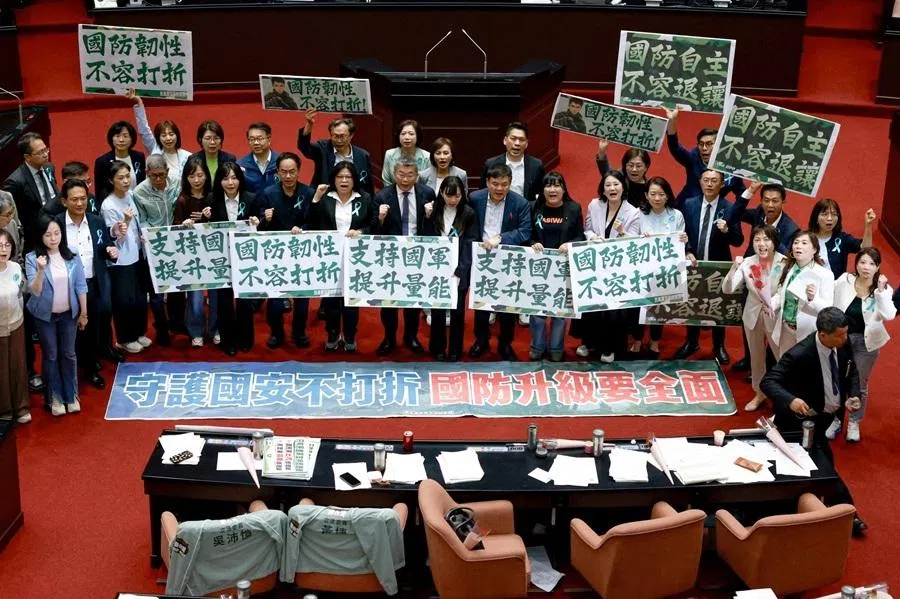 Members of the ruling Democratic Progressive Party (DPP) hold signs after the opposition-controlled parliament approved a US$25 billion special defence spending budget, at the Legislative Yuan in Taipei, Taiwan, 8 May 2026.