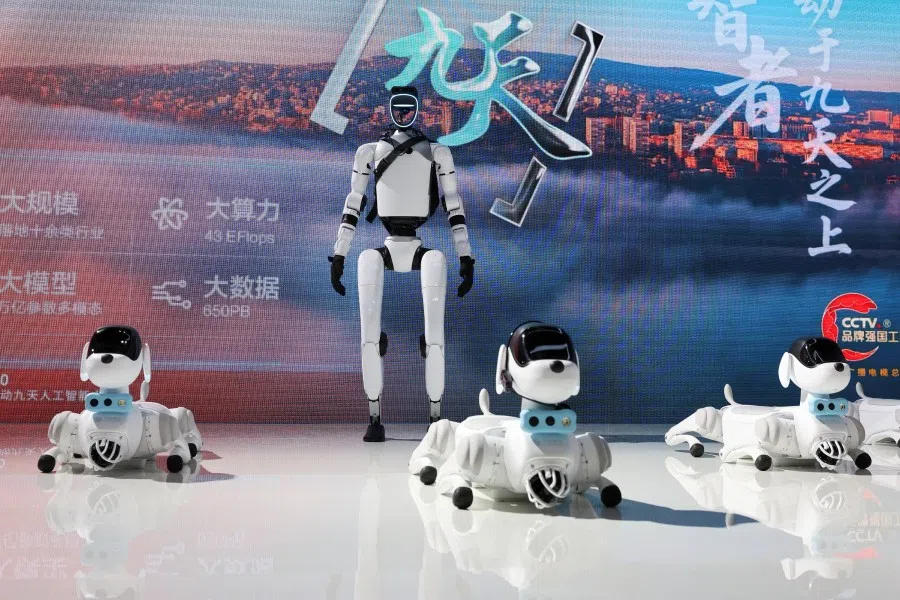 A humanoid robot and robot dogs are displayed at a China Mobile booth during the World Artificial Intelligence Conference in Shanghai, China, on 26 July 2025. (Go Nakamura/Reuters)
