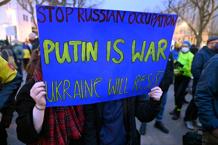 Pro-Ukraine demonstrators hold a placard during a demonstration in front of the Russian embassy in Berlin, Germany, on 22 February 2022. (John Macdougall/AFP)