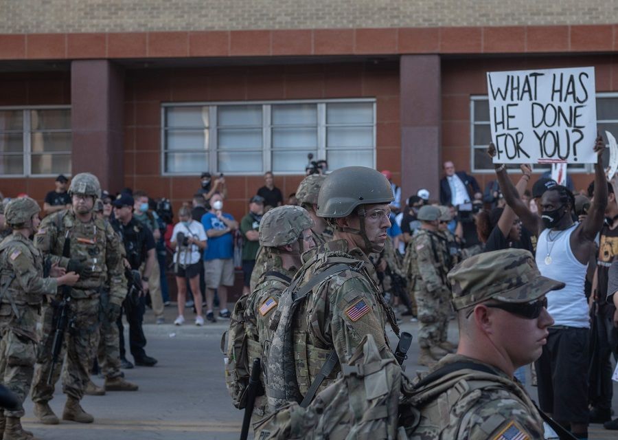 Members of the National Guard stand in formation as protesters march and protest near the BOK Center in Tulsa, Oklahoma on 20 June 2020. (Seth Herald/AFP)