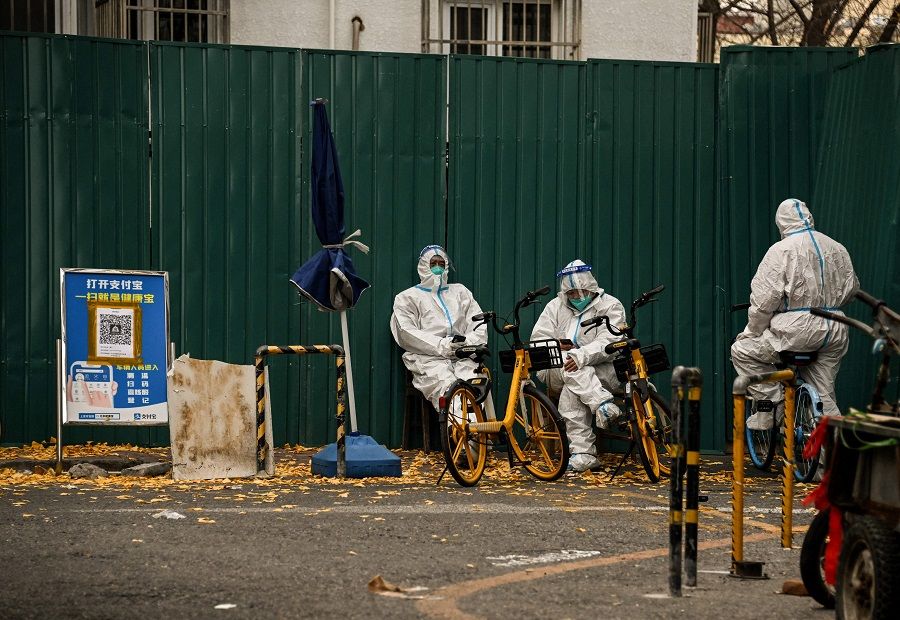 Security personnel wearing personal protective equipment guard the entrance to a residential area under lockdown due to Covid-19 restrictions in Beijing, China, on 22 November 2022. (Noel Celis/AFP)