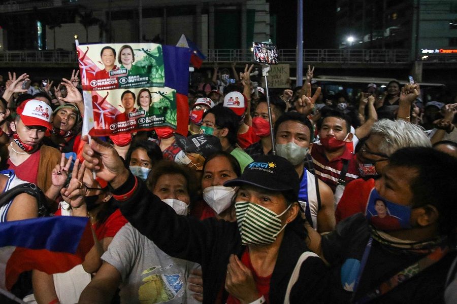 Supporters of Philippine presidential candidate Ferdinand Marcos Jr celebrate outside his campaign headquarters after his landslide presidential election victory, in Mandaluyong City, Metro Manila, on 11 May 2022. (Jam Sta Rosa/AFP)
