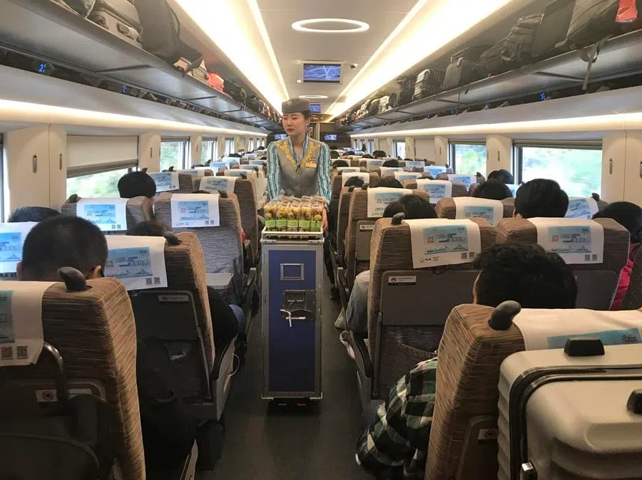 A train attendant pushing a trolley with snacks, hot drinks, fruit and bentos comprising steamed rice, vegetables and meat on China’s high-speed train, January 2019. (SPH Media)