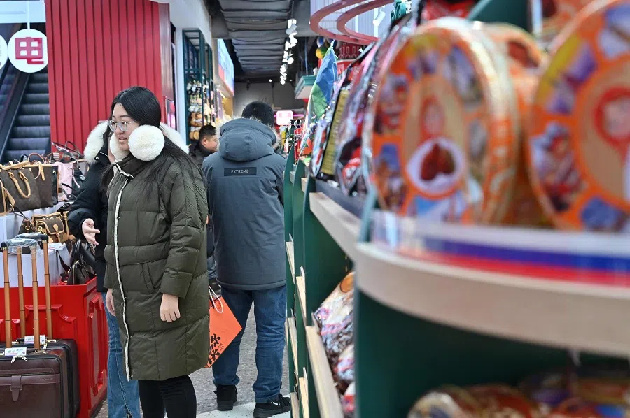 This picture taken on 16 December 2024 shows people shopping in Harbin, Heilongjiang province, China. (Adek Berry/AFP)