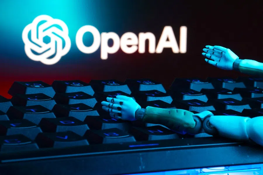 The OpenAI logo, a keyboard, and robot hands are seen in this illustration taken on 27 January 2025. (Dado Ruvic/Illustration/Reuters)