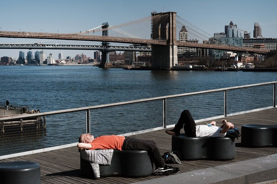 People relax in the sun in Manhattan on a warm afternoon on 9 March 2021 in New York City. (Spencer Platt/Getty Images/AFP)