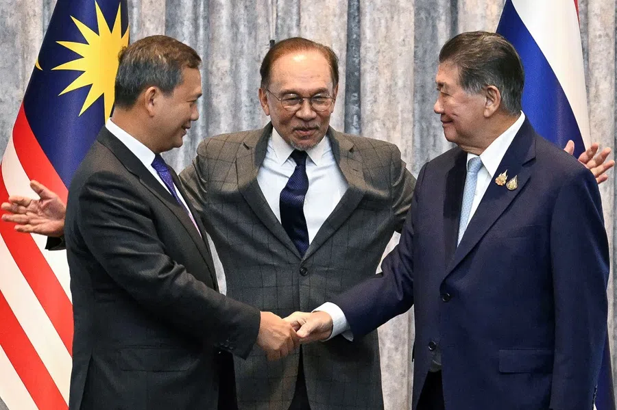Malaysia’s Prime Minister Anwar Ibrahim reacts as Cambodia’s Prime Minister Hun Manet and Thailand’s acting Prime Minister Phumtham Wechayachai shake hands following a press conference, on the day of mediation talks on the Thailand–Cambodia border conflict, in Putrajaya, Malaysia on 28 July 2025. 