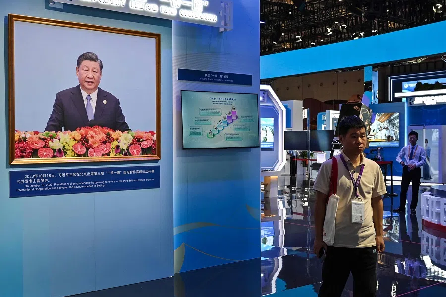 A portrait of China's President Xi Jinping is seen as people visit the China stand during the 6th China International Import Expo (CIIE) in Shanghai on 5 November 2023. (Hector Retamal/AFP)