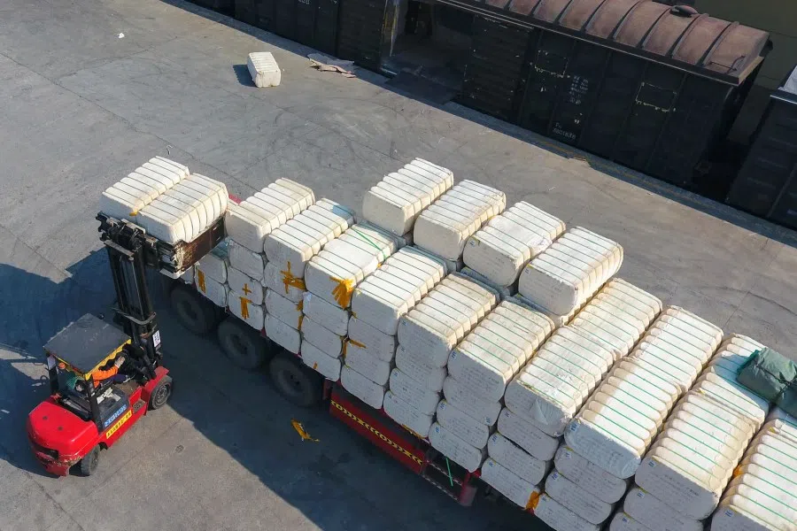 This aerial photo taken on 26 March 2021 shows a worker unloading cotton picked from Xinjiang at a railway station in Jiujiang in China's central Jiangxi province. (STR/AFP)