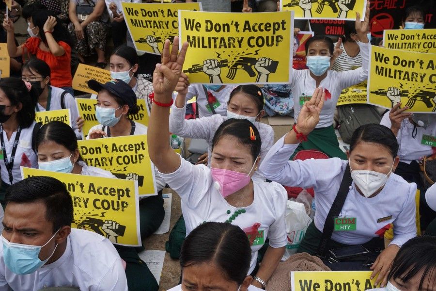Protesters hold up signs during a demonstration against the military coup in front of the Chinese embassy in Yangon on 18 February 2021. (Sai Aung Main/AFP)