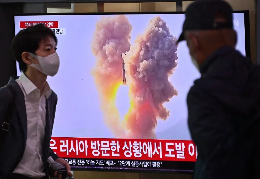 A man walks past a television screen showing a news broadcast with file footage of a North Korean missile test, at a railway station in Seoul, South Korea, on 13 September 2023. (Jung Yeon-je/AFP)