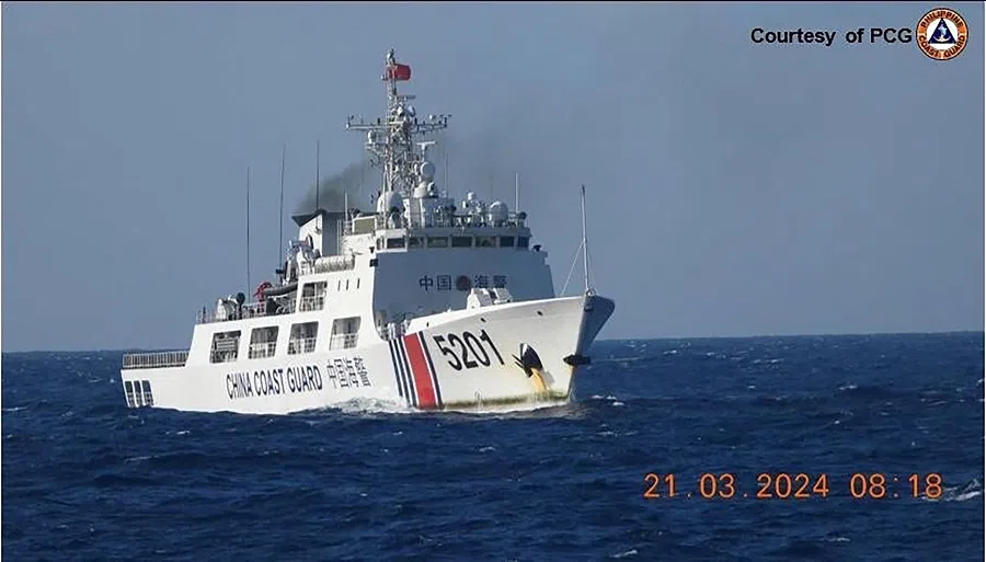 In this handout frame grab video footage taken on 21 March 2024 and received from the Philippine Coast Guard (PCG) on 22 March, a Chinese Coast Guard ship shadows a PCG ship (not pictured) near Sandy Cay reef, near the Philippine-held Thitu Island in Spratly Islands, in the disputed South China Sea. (Philippine Coast Guard/AFP)