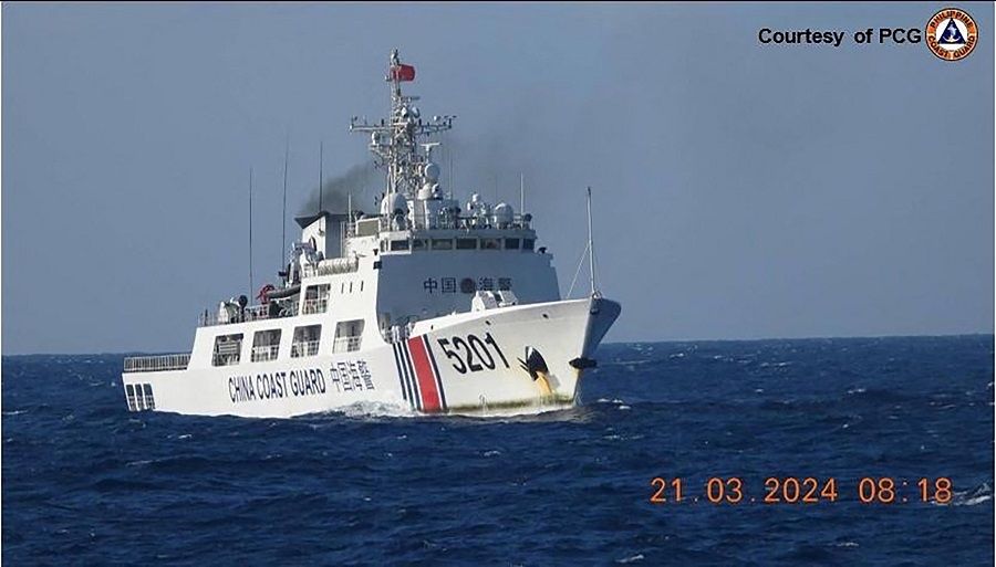 In this handout frame grab video footage taken on 21 March 2024 and received from the Philippine Coast Guard (PCG) on 22 March, a Chinese Coast Guard ship shadows a PCG ship (not pictured) near Sandy Cay reef, near the Philippine-held Thitu Island in Spratly Islands, in the disputed South China Sea. (Philippine Coast Guard/AFP)