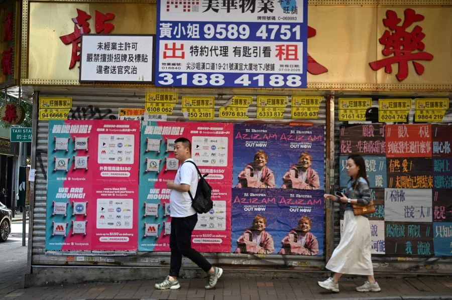 People pass a closed down retail store in Hong Kong on 16 April 2025. (Peter Parks/AFP)